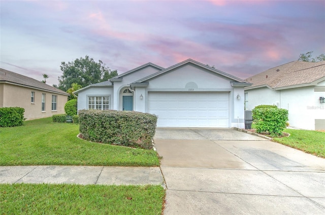 single story home featuring a yard and a garage