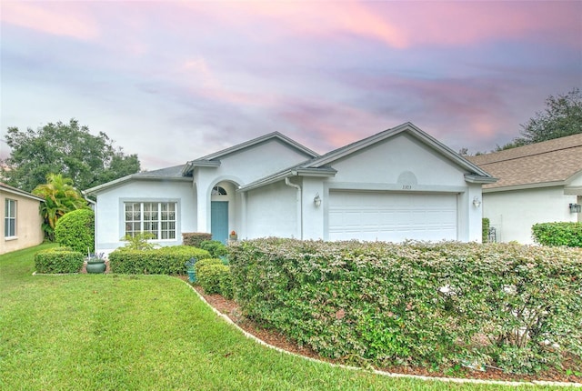 ranch-style house featuring a lawn and a garage