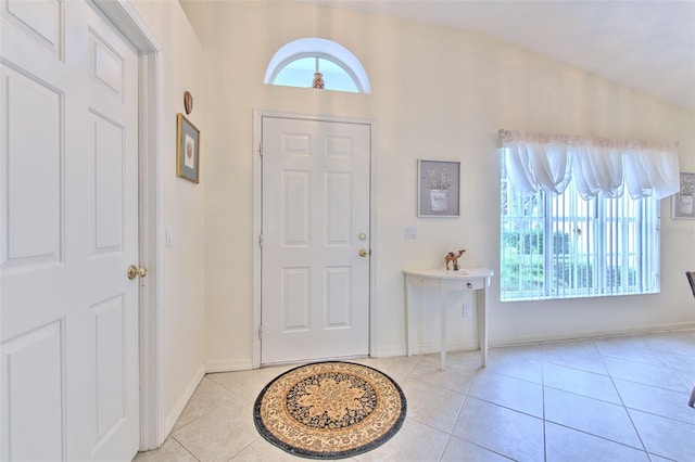 tiled foyer entrance featuring vaulted ceiling