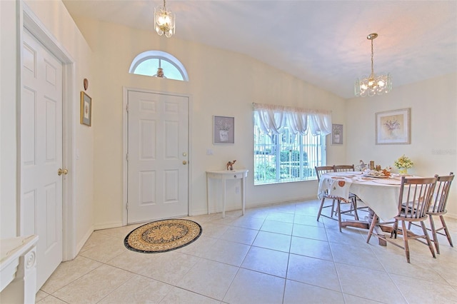 entrance foyer featuring a notable chandelier, vaulted ceiling, and light tile patterned flooring