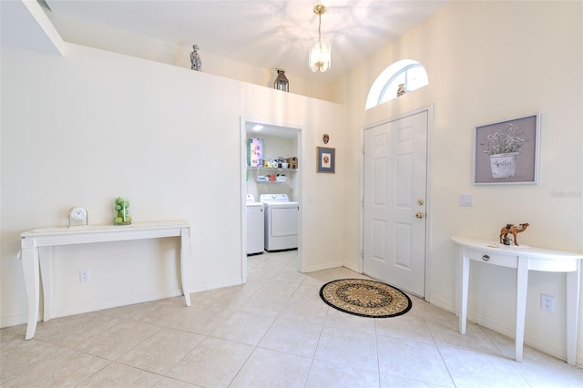 tiled foyer entrance with washer and clothes dryer