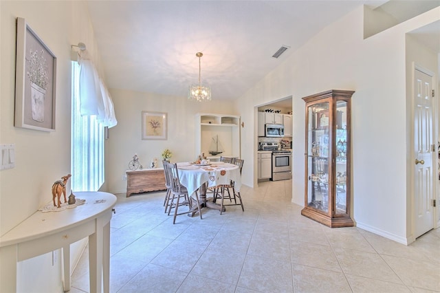 tiled dining space featuring a notable chandelier and lofted ceiling