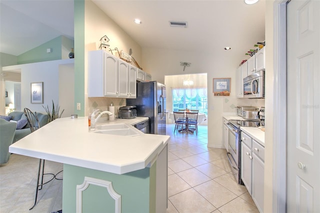 kitchen featuring white cabinets, appliances with stainless steel finishes, kitchen peninsula, and a kitchen breakfast bar