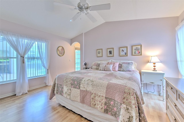 bedroom with ceiling fan, light wood-type flooring, and vaulted ceiling