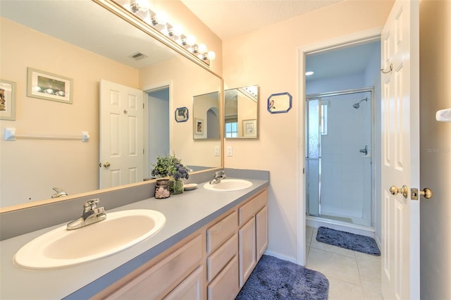 bathroom featuring vanity, a shower with shower door, and tile patterned flooring