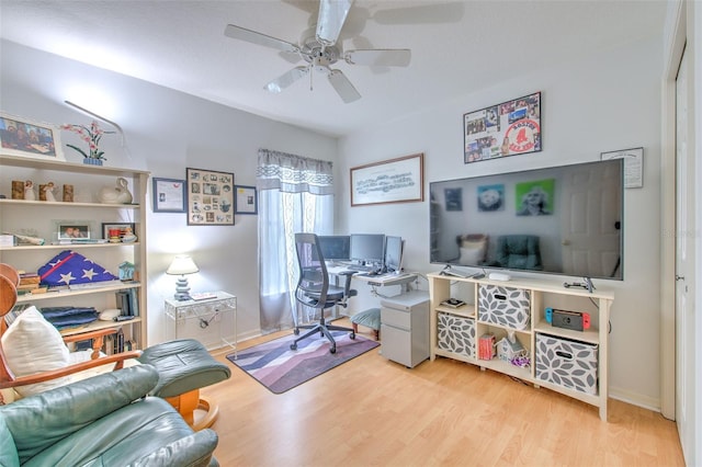 home office with light hardwood / wood-style floors and ceiling fan