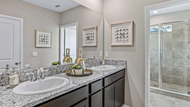 bathroom featuring tile patterned flooring, vanity, and a shower with shower door