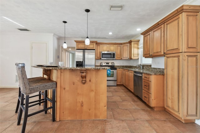 kitchen featuring crown molding, dark stone countertops, decorative light fixtures, a kitchen island, and stainless steel appliances