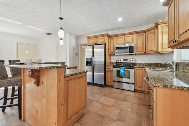 kitchen featuring pendant lighting, dark stone counters, sink, appliances with stainless steel finishes, and a kitchen island