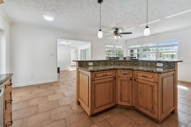 kitchen with a center island, hanging light fixtures, dark stone counters, and ceiling fan