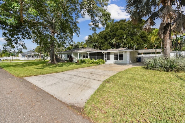 ranch-style home with a front yard and a carport