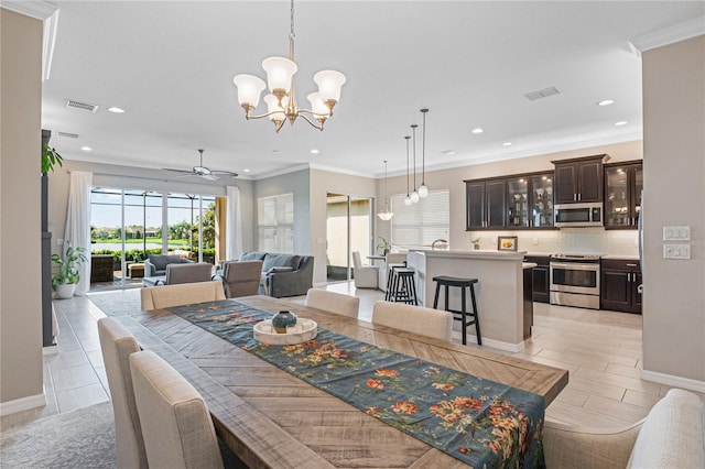 dining area featuring ceiling fan with notable chandelier and crown molding