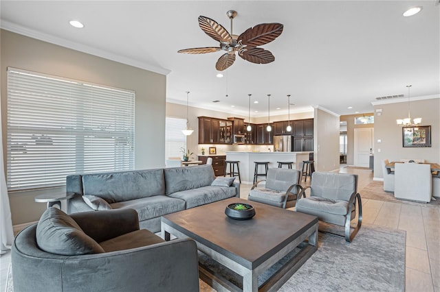 living room with light wood-type flooring, ceiling fan with notable chandelier, and ornamental molding