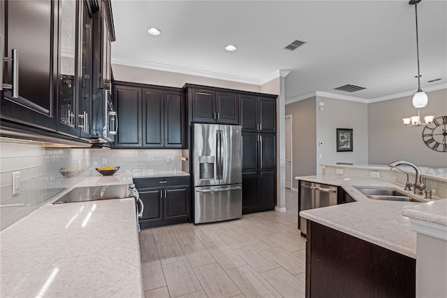 kitchen featuring sink, light stone counters, crown molding, decorative light fixtures, and appliances with stainless steel finishes