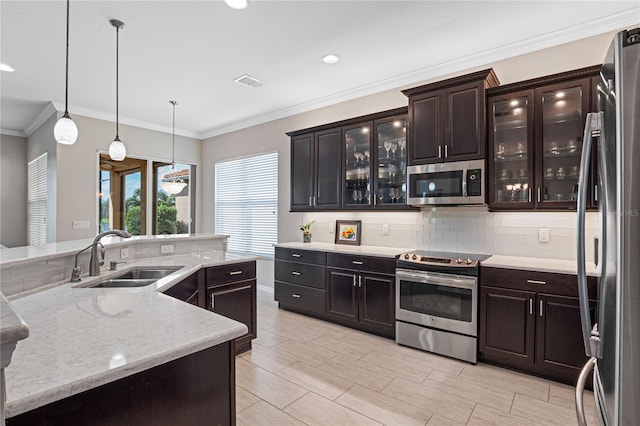 kitchen featuring appliances with stainless steel finishes, tasteful backsplash, ornamental molding, sink, and decorative light fixtures