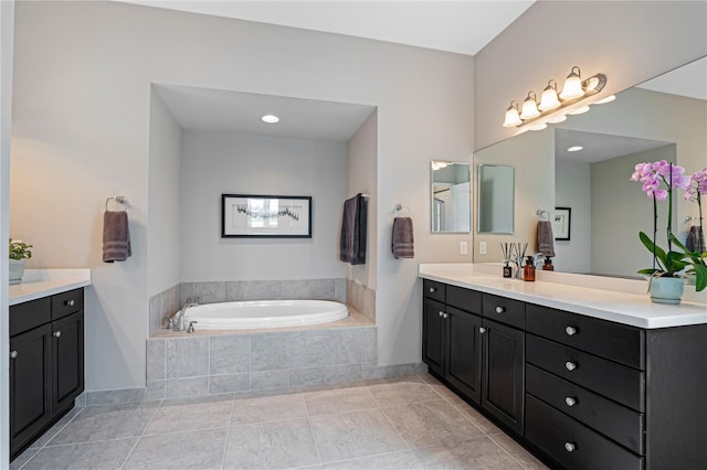 bathroom with tile patterned floors, tiled bath, and vanity