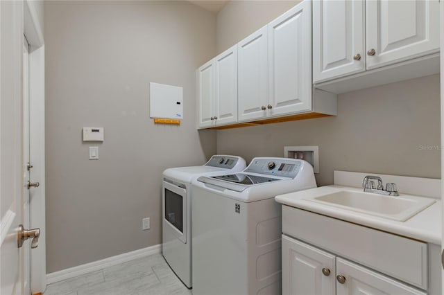 clothes washing area featuring cabinets, independent washer and dryer, and sink