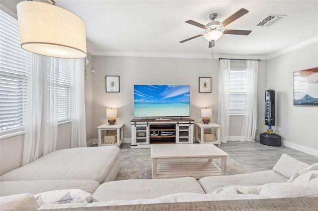 living room featuring ornamental molding, ceiling fan, and plenty of natural light