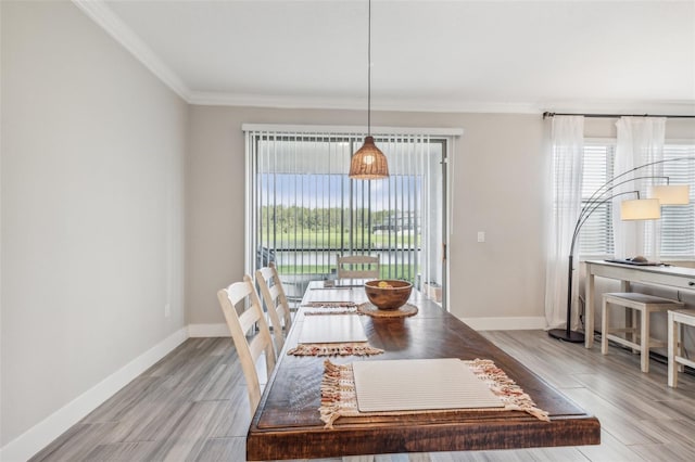 dining space with light hardwood / wood-style flooring and crown molding