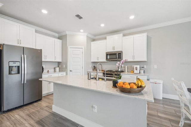 kitchen with white cabinets, a center island with sink, and appliances with stainless steel finishes