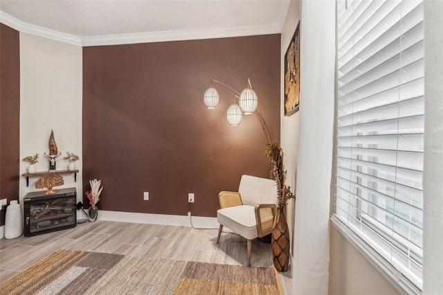 sitting room featuring light wood-type flooring, a fireplace, and ornamental molding