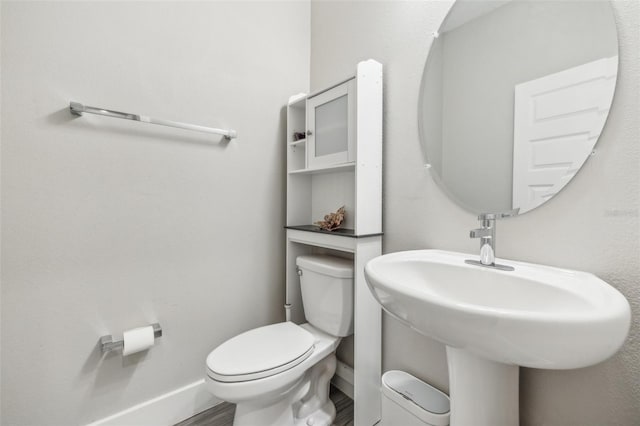 bathroom with hardwood / wood-style flooring and toilet