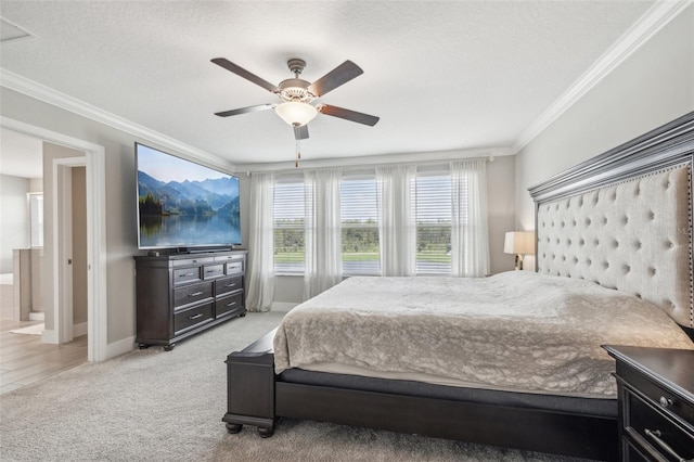 bedroom with ceiling fan, a textured ceiling, light carpet, and ornamental molding