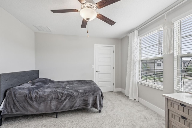 carpeted bedroom with ceiling fan, a textured ceiling, and multiple windows