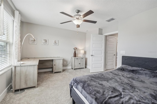 carpeted bedroom with ceiling fan and a textured ceiling