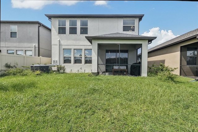 back of house with cooling unit and a lawn