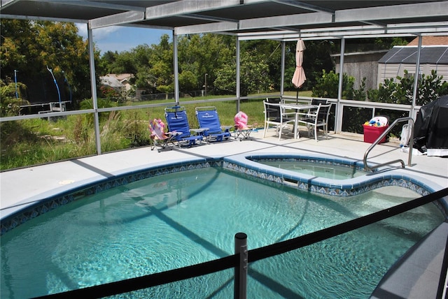 view of pool with a lanai, a patio, and an in ground hot tub