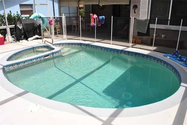 view of swimming pool with a patio and an in ground hot tub