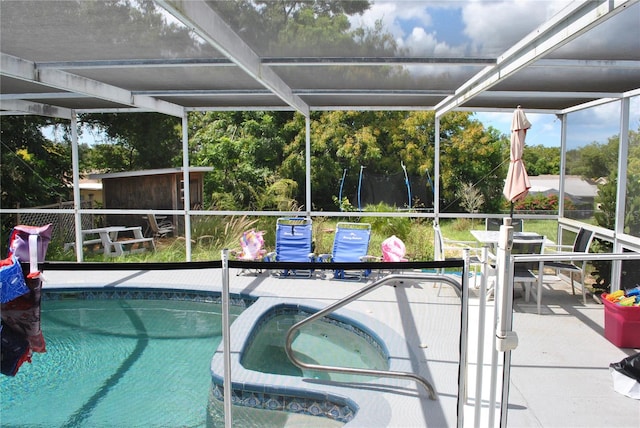 view of swimming pool with an in ground hot tub, a lanai, and a patio area