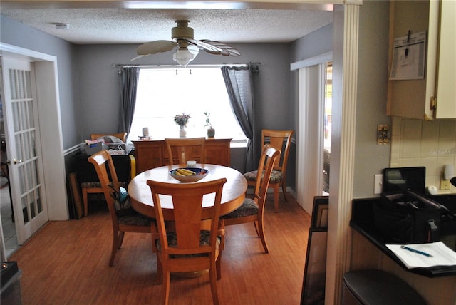 dining space featuring ceiling fan, hardwood / wood-style flooring, and a textured ceiling