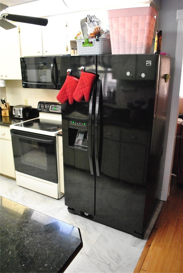 kitchen featuring black appliances, light hardwood / wood-style floors, white cabinetry, and tasteful backsplash