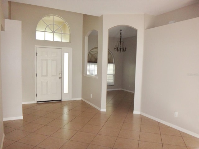 tiled entryway featuring a notable chandelier and plenty of natural light