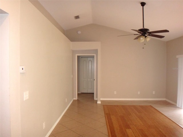 empty room featuring ceiling fan, light tile patterned flooring, and lofted ceiling