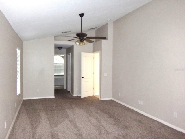 interior space featuring dark carpet, lofted ceiling, and ceiling fan