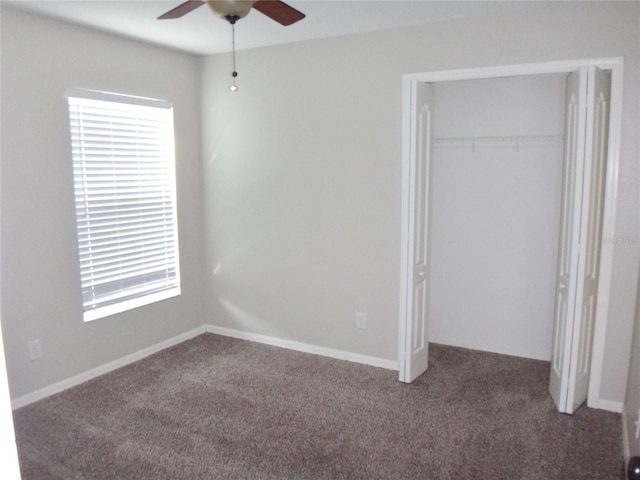 unfurnished bedroom featuring dark colored carpet, ceiling fan, and a closet