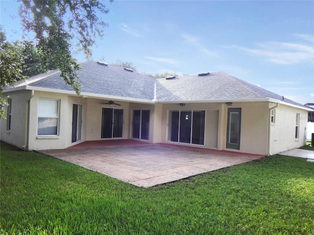 rear view of house featuring ceiling fan, a lawn, and a patio area