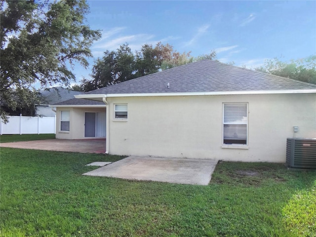 back of property with a patio, central AC, and a yard