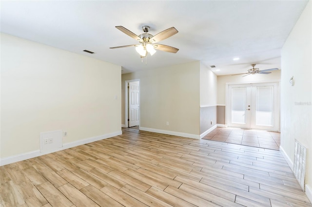 unfurnished room featuring ceiling fan, light wood-type flooring, and french doors