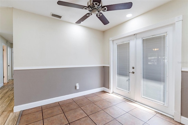 tiled empty room with ceiling fan and french doors