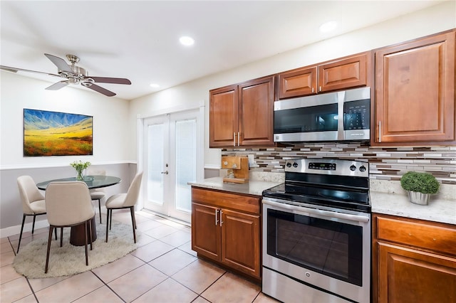 kitchen featuring ceiling fan, light stone counters, light tile patterned floors, backsplash, and stainless steel appliances