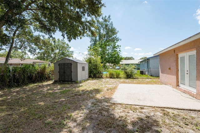 view of yard featuring a storage unit and a patio