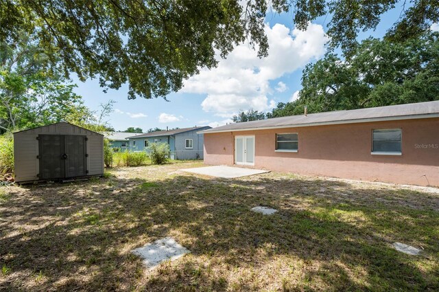 back of property featuring a storage unit and a patio area