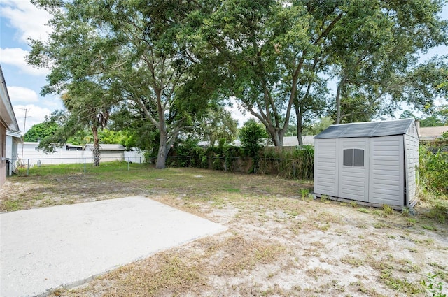 view of yard featuring a storage unit and a patio