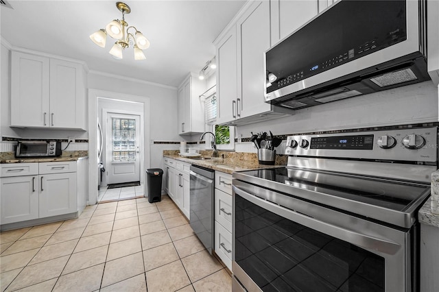 kitchen featuring sink, white cabinetry, stainless steel appliances, light tile patterned floors, and ornamental molding