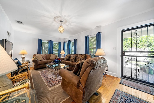 living room featuring plenty of natural light, light hardwood / wood-style floors, and crown molding