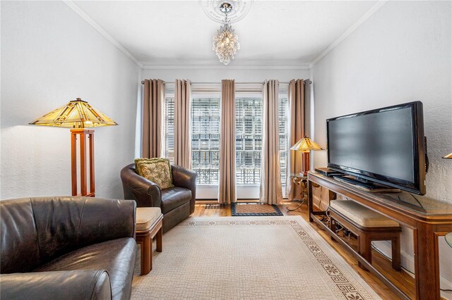 sitting room with ornamental molding, light hardwood / wood-style flooring, and a notable chandelier